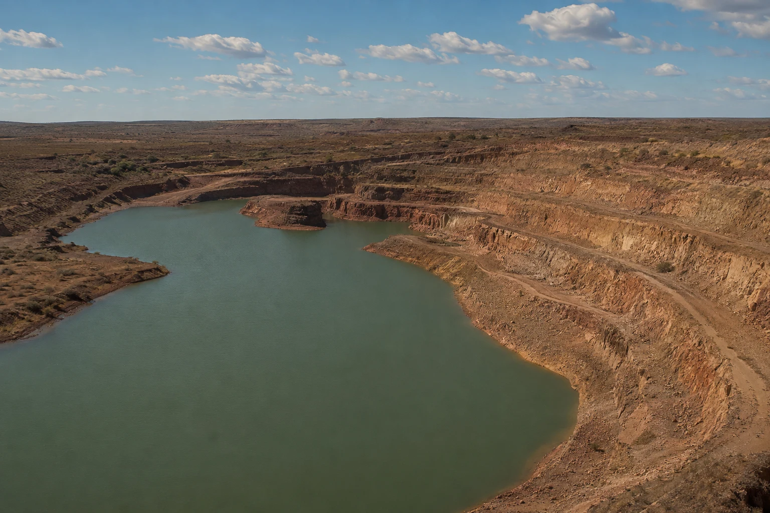 Illustrative terraced mine landscape with pit water and an arid horizon